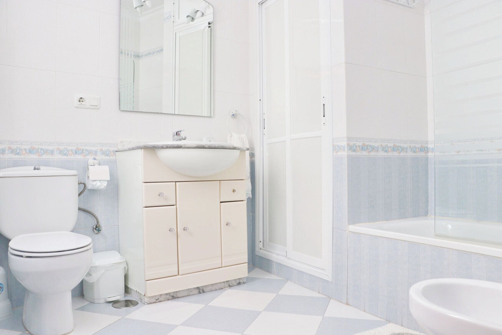 Une salle de bain avec des toilettes, un lavabo et une douche.