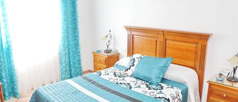 Ein Schlafzimmer mit einem Bett, einem Nachttisch, einer Kommode und einem Bild an der Wand.