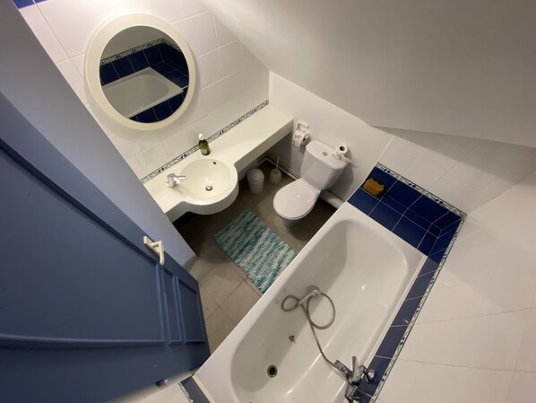 A bathroom with a sink, toilet, and bathtub.