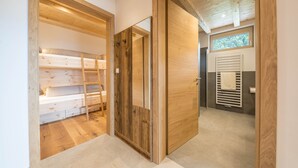 Un interior de madera con una cama litera, una puerta y una ventana.
