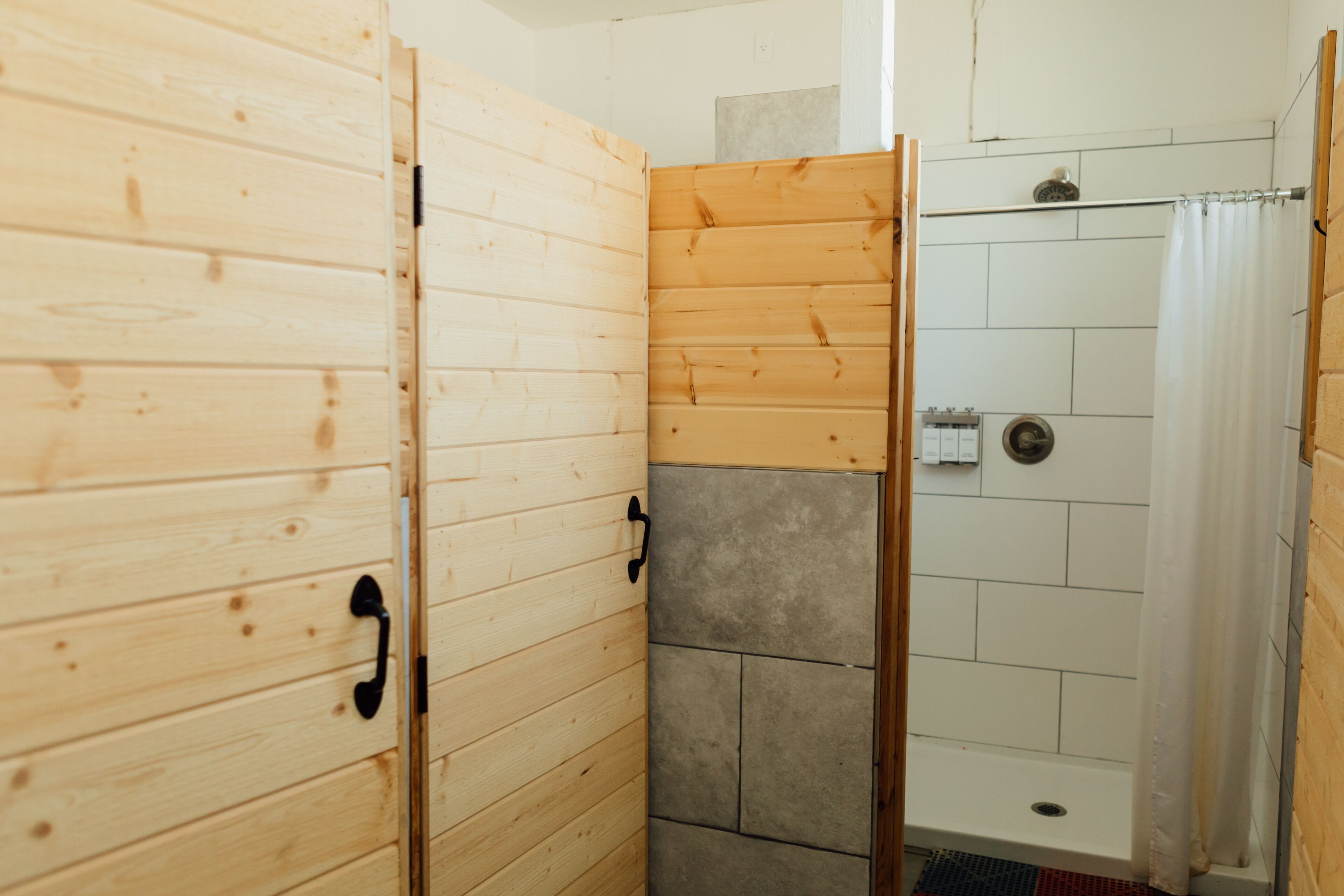 A wooden room with a shower area.