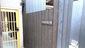 Ein hölzernes Tor mit einem Schild, auf dem „HOTEL IN“ steht, und einem Zahlenschloss.