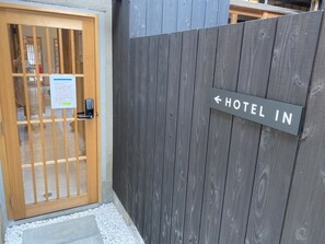 A wooden gate with a sign indicating the direction to the hotel. - Bito Tsuyama-An LWx (Tsuyama)