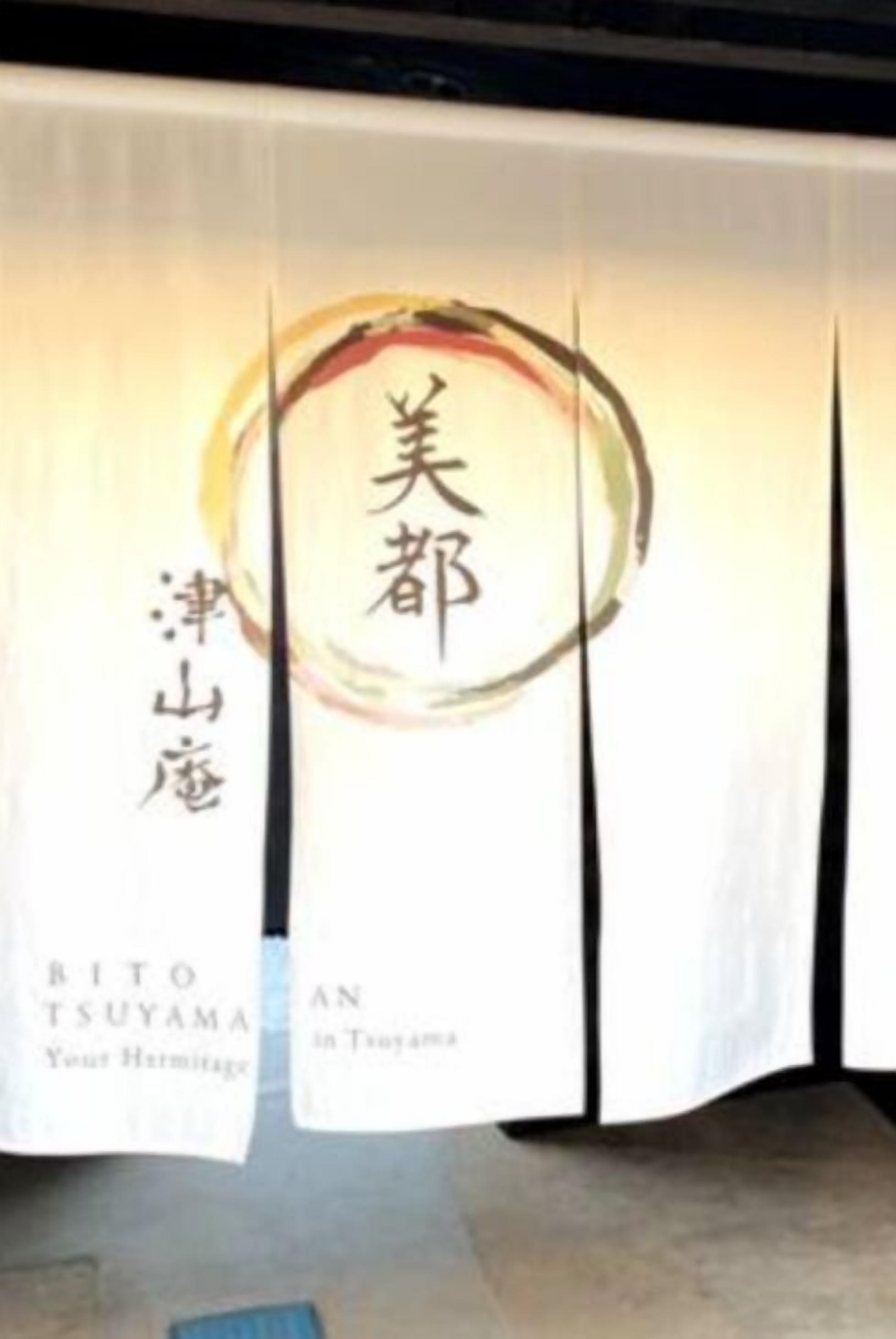 Um banner com caracteres japoneses e o texto 'Bito Tsuyama Your Heritage' e 'An in Tsuyama'.