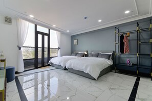 Un dormitorio moderno con una cama grande, un balcón con cortinas, un armario empotrado y suelo de mármol.