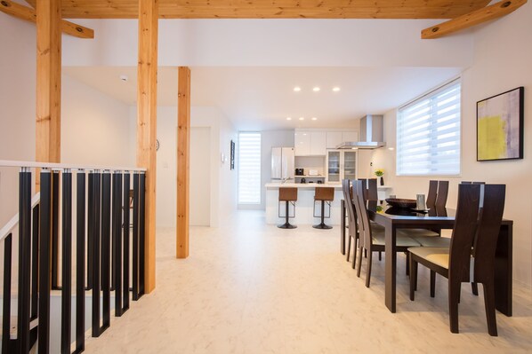 Una cocina moderna con armarios blancos, una isla central y taburetes de bar.