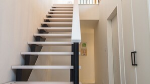 Una escalera moderna con techo de madera y paredes blancas.