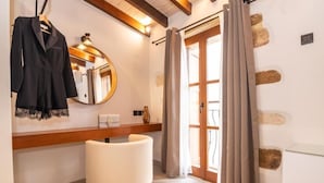 Een moderne badkamer met een witte wastafel, een spiegel en een ophanghaak voor een badjas.