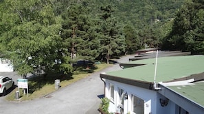 A building with a green roof, surrounded by trees and a parking area. - Inter-Alp (Saint-Maurice)