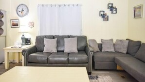 A living room with a sofa set, a coffee table, and a side table with a lamp.