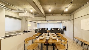 A conference room with a long table set for a meeting, surrounded by chairs, with a sofa and a whiteboard in the background. -  Dai3Himawari 604 (Hiroshima)