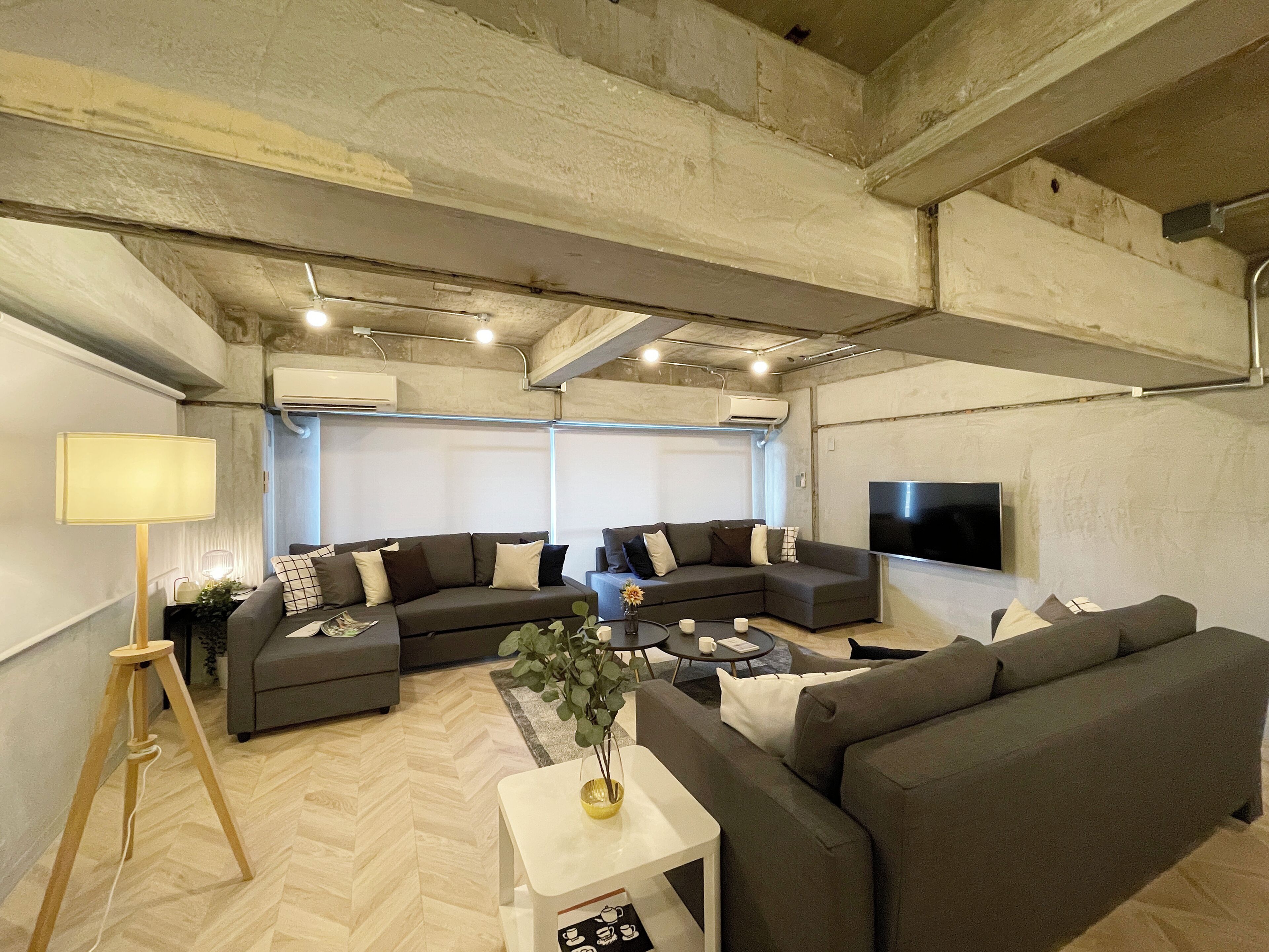 A modern living room with a sectional sofa, a coffee table, and a lamp.