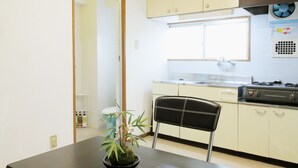 Una cocina compacta con una mesa, sillas y una planta en maceta.