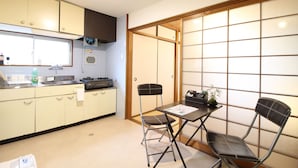 Una cocina compacta con comedor, que incluye una mesa, sillas, un fregadero y un ventanal.