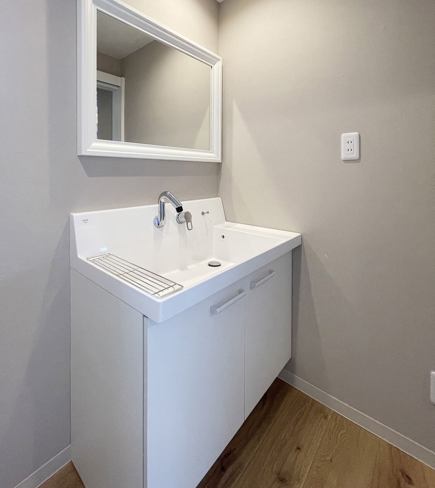 Un meuble-lavabo blanc pour la salle de bain, avec un miroir, un évier et un placard.