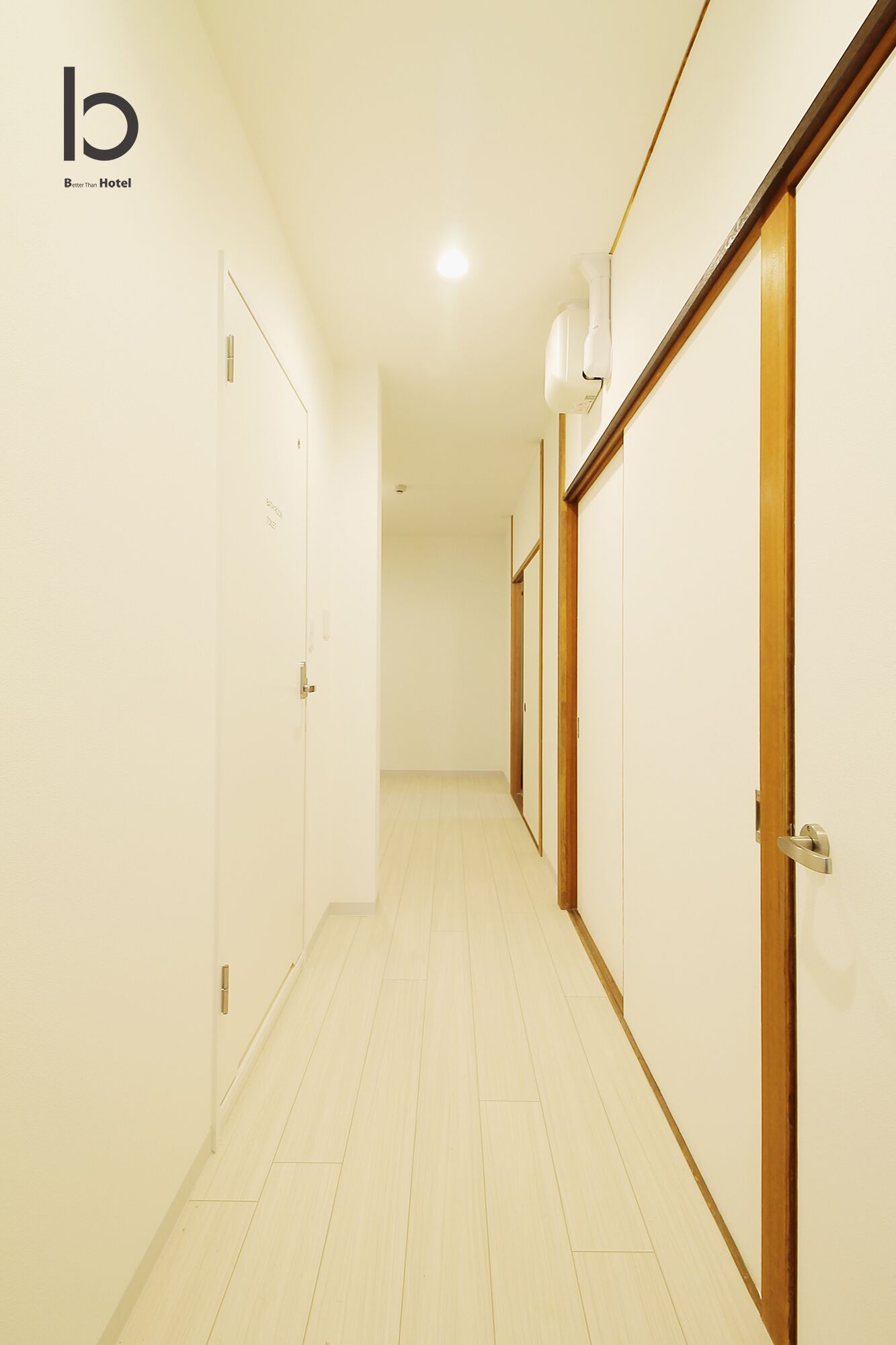 A hotel corridor with wooden doors and a tiled floor.