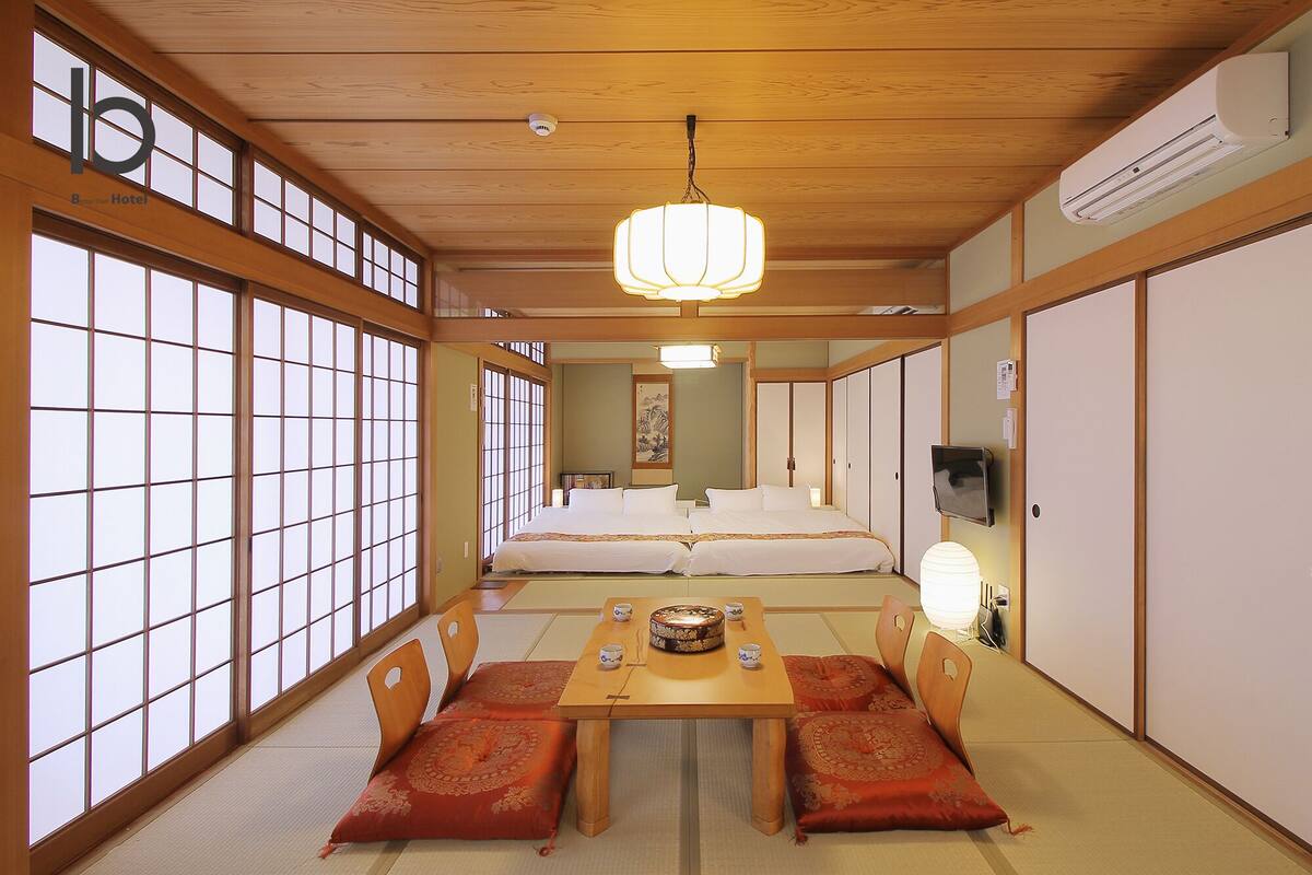 A traditional Japanese-style room with tatami flooring, a low table with cushions, and sliding doors.