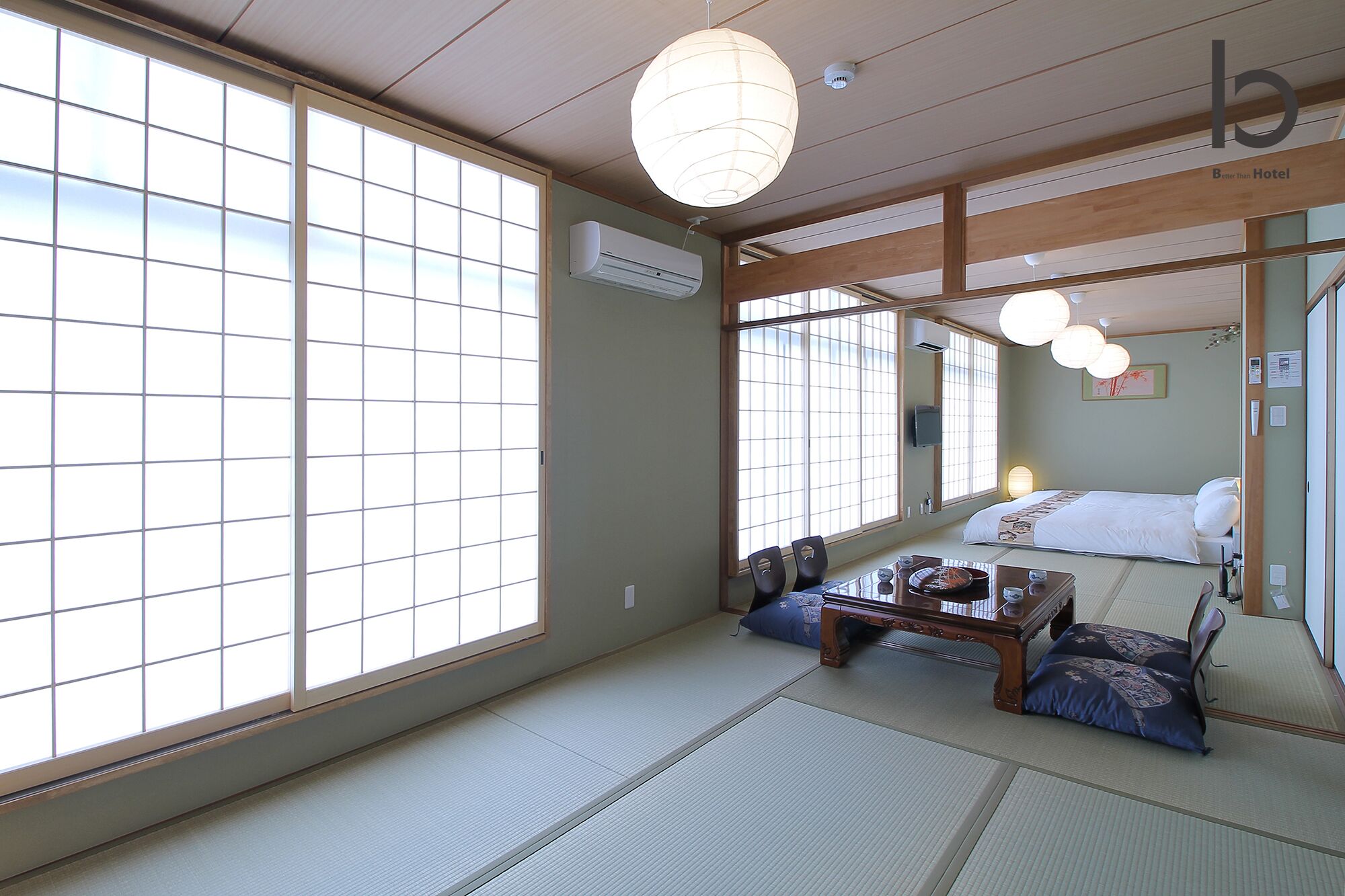A traditional Japanese room with tatami flooring, a low wooden bed, and a sliding shoji screen door.