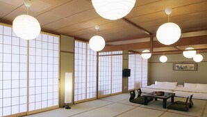 A traditional Japanese-style room with tatami flooring, shoji screens, and multiple hanging paper lanterns. - Hanagin Building (Hiroshima)