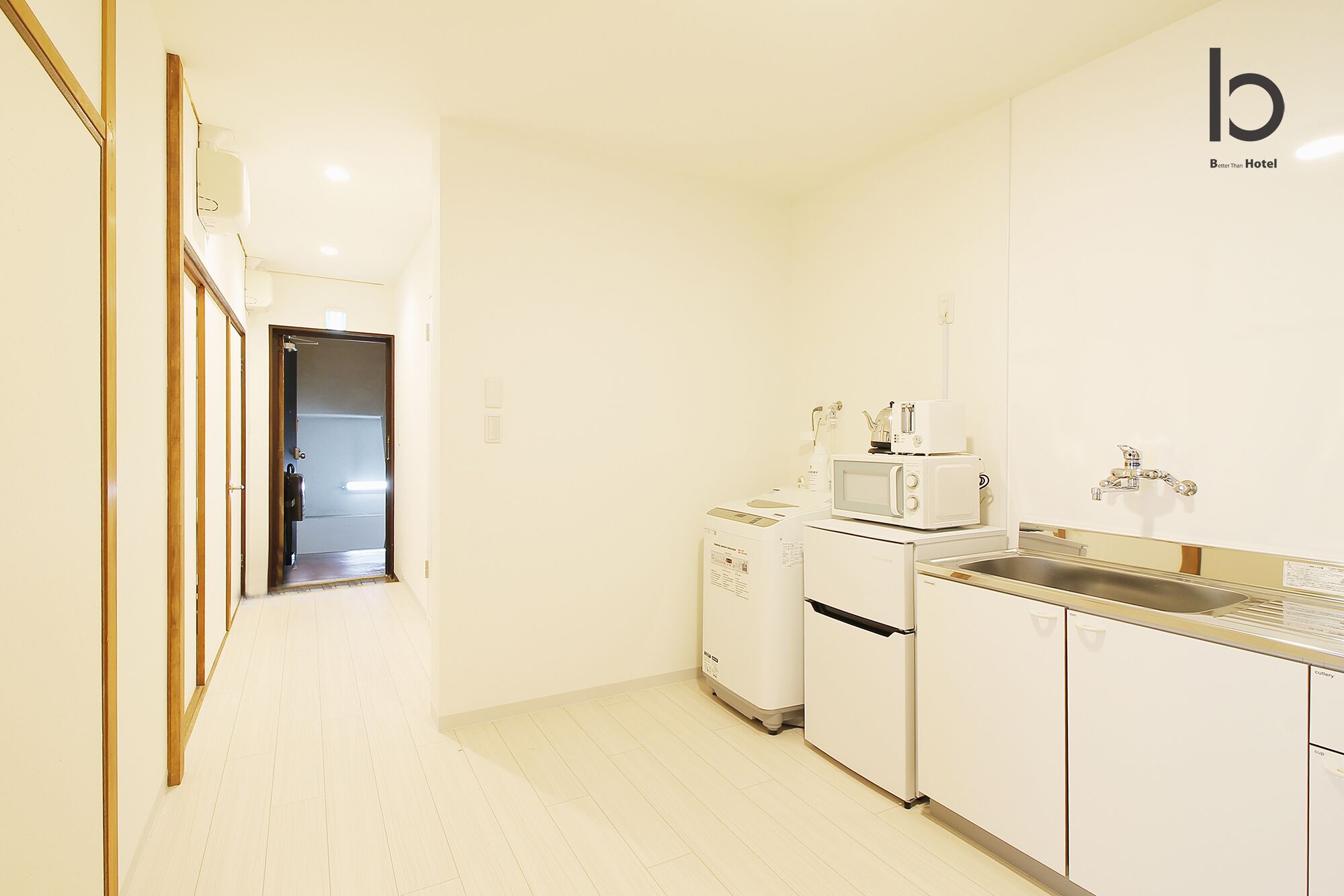 A compact hotel kitchen with a microwave, toaster, and sink.