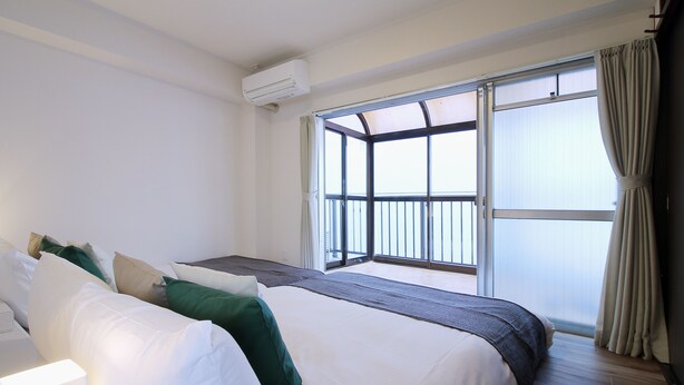 Ein Hotelzimmer mit einem großen Bett, einem Nachttisch und einem Fenster mit Vorhängen.