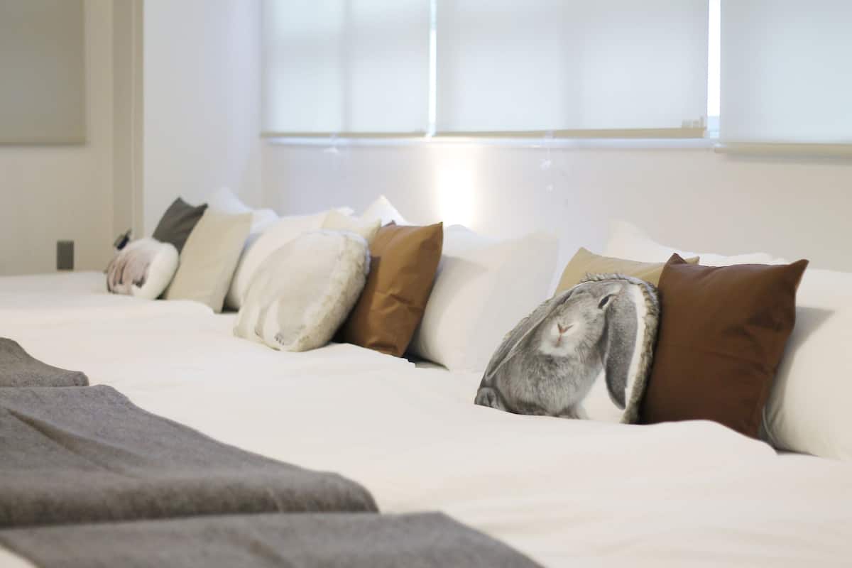 Una cama bien hecha con una variedad de almohadas y una manta.