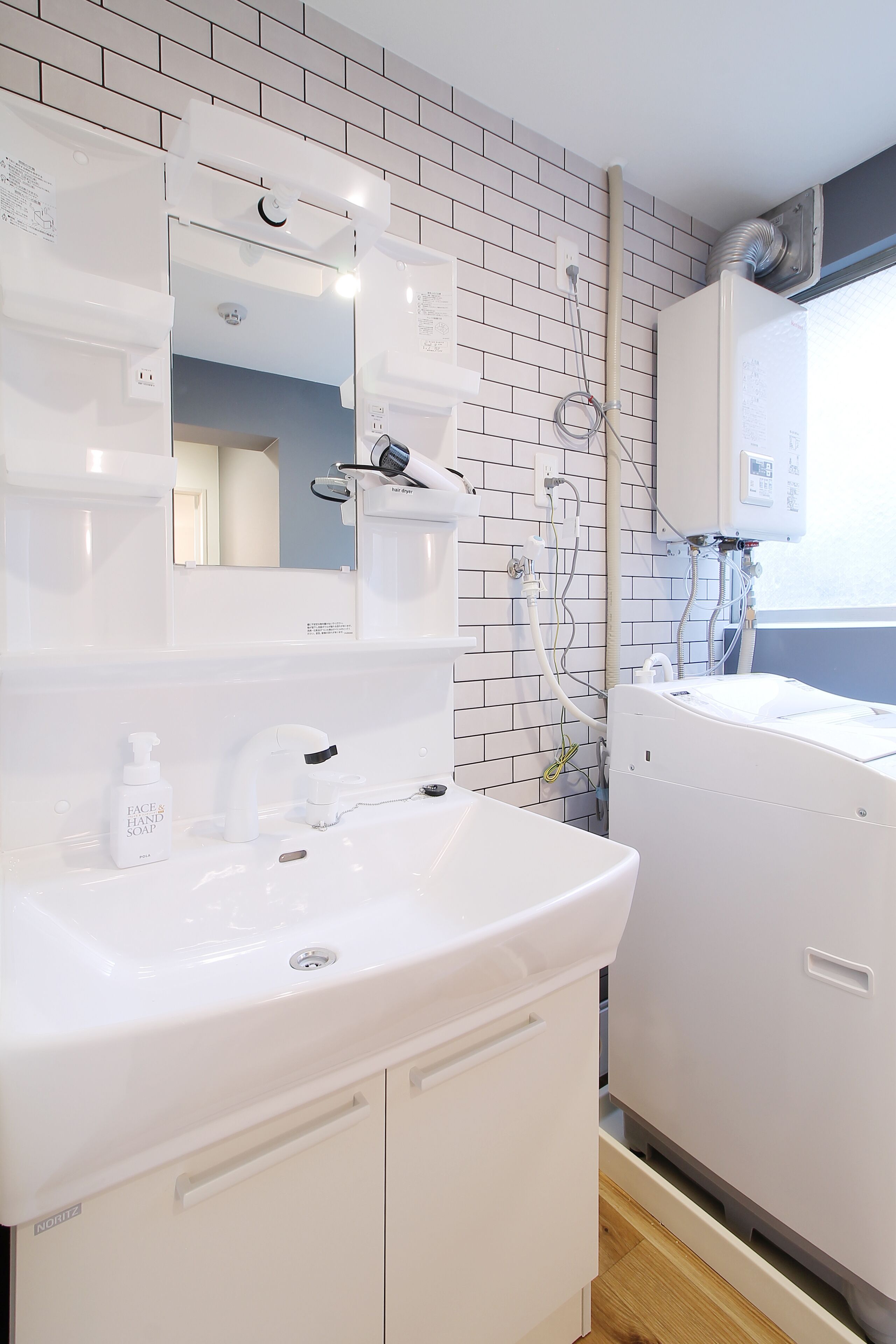 A modern bathroom with a white sink, mirror, and a built-in shower.