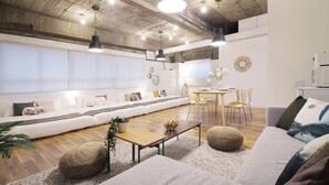 A modern living room with a sofa set, wooden coffee table, and a dining area with chairs.