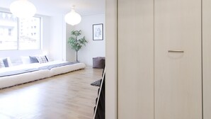 A modern room with a large sliding door closet, a seating area with a view, and a potted plant.