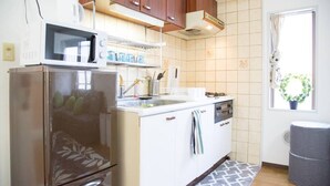 Una cocina compacta equipada con refrigerador, microondas y lavamanos.