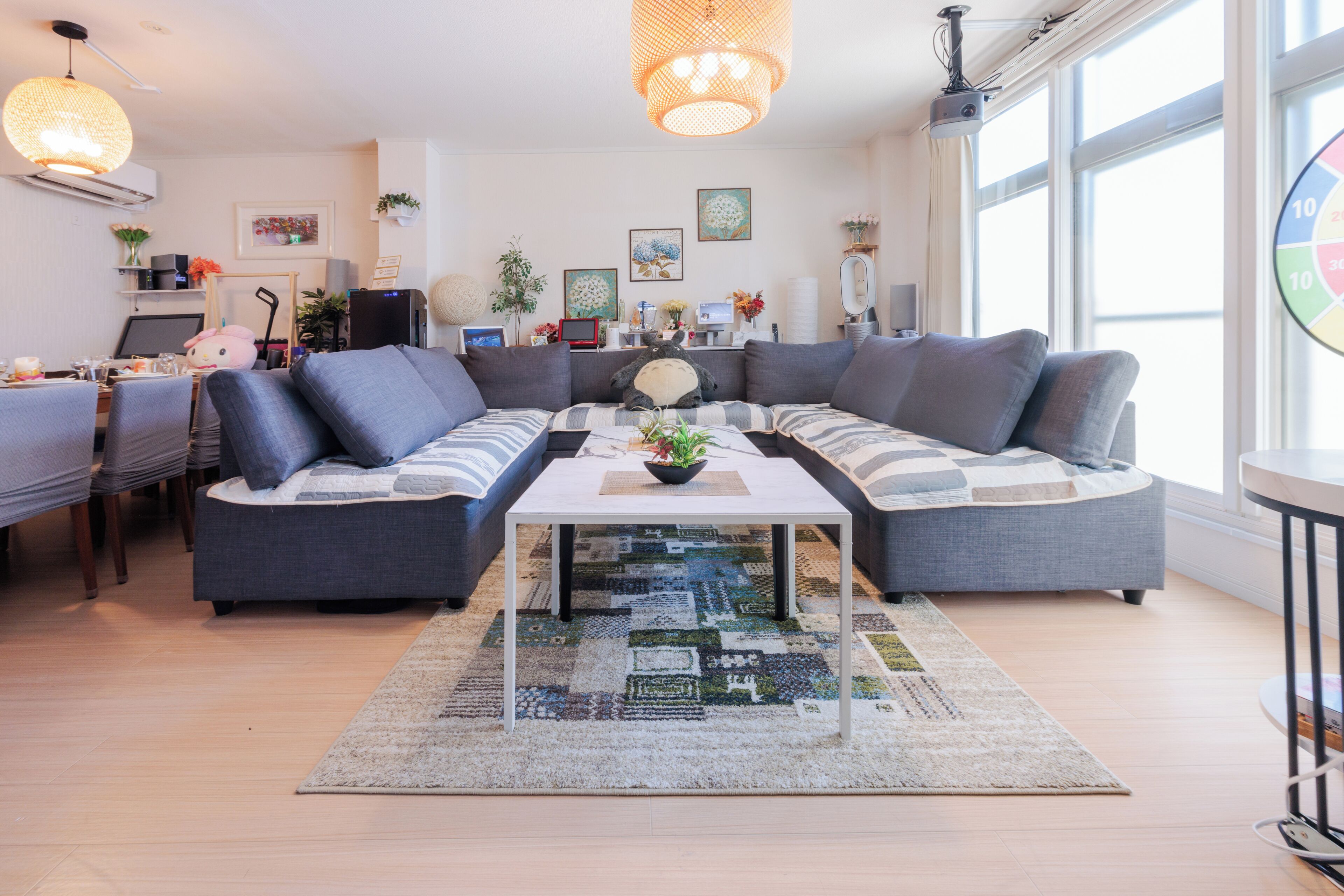 Una sala moderna con un sofá modular, una mesa de centro y un comedor con sillas.