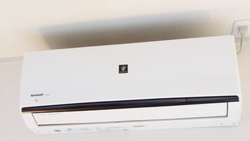 Eine weiße Klimaanlage mit dem Markenname 'SHARP' und der Modellnummer 'AC-228TN' auf der Vorderseite.