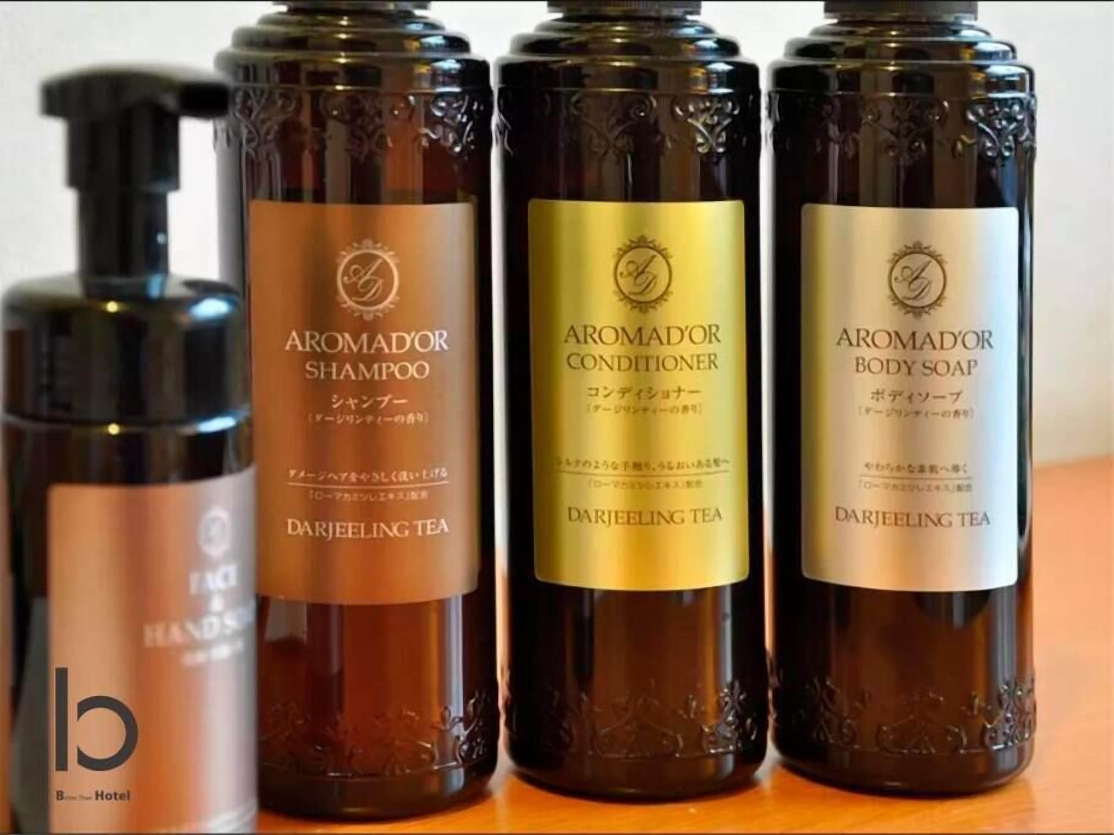Four bottles of Darjeeling tea-based aromadour products: shampoo, conditioner, and body soap.