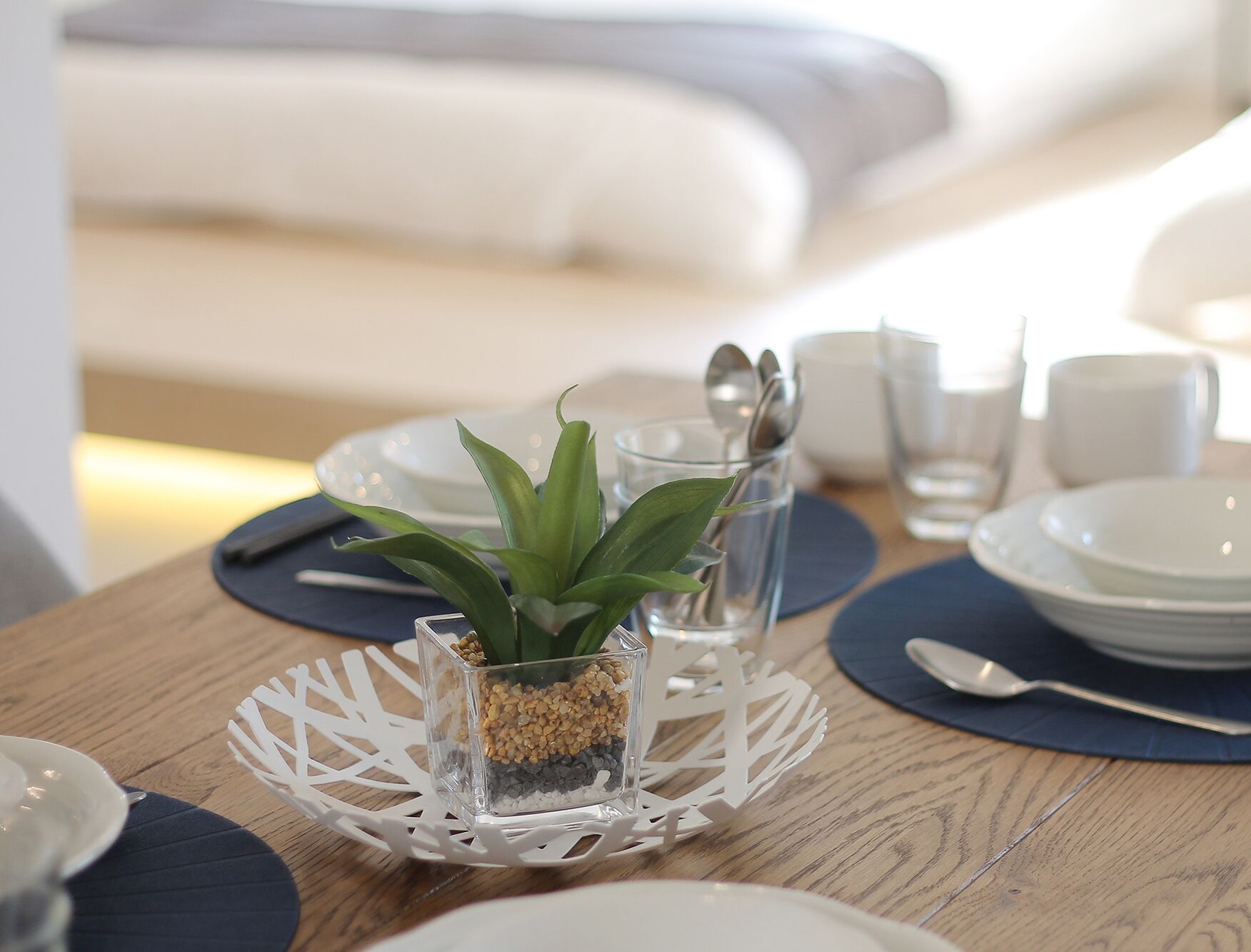 Une table à manger agrémentée d’un arrangement floral, de assiettes, de verres et de couverts.