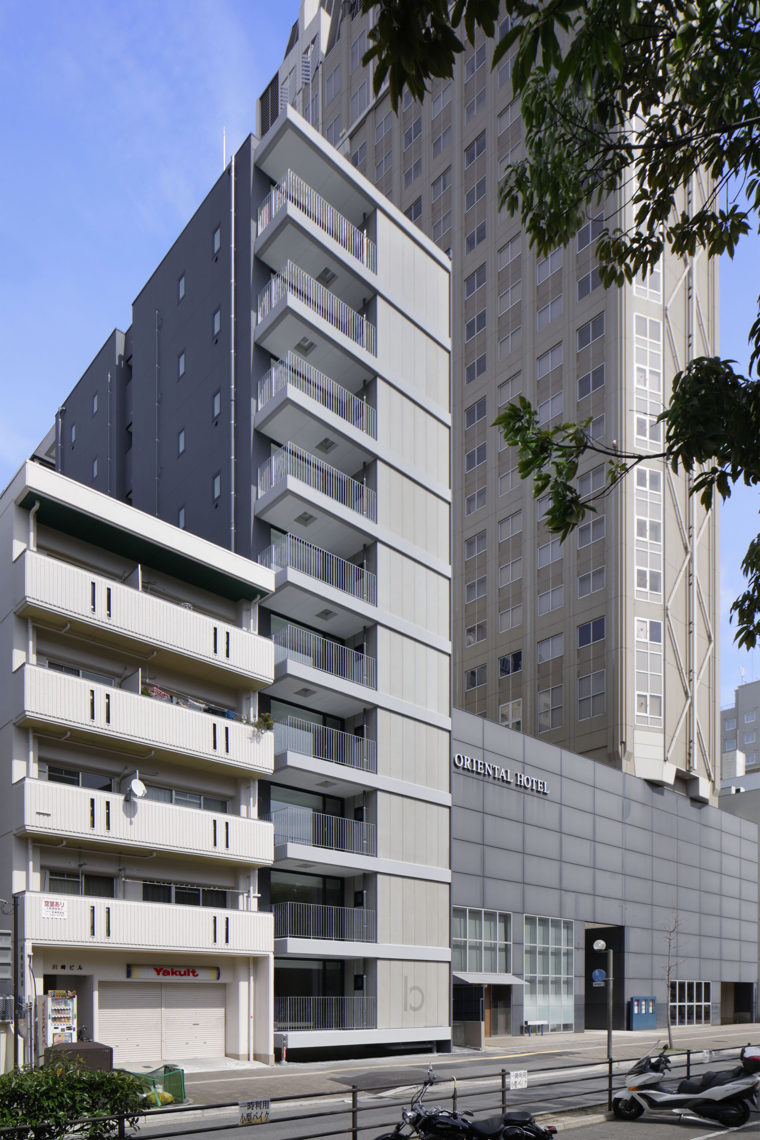 A modern building with multiple balconies and a sign for the Oriental Hotel.