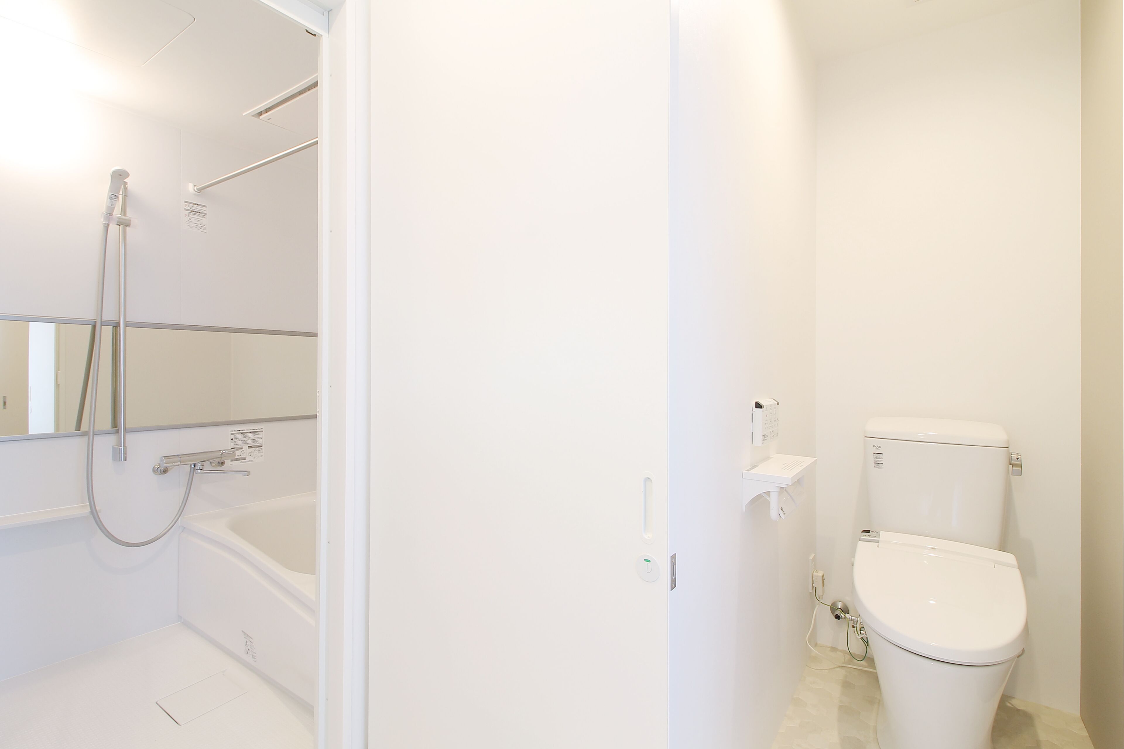 Een badkamer met een bad, toilet en douche.