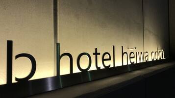 Señal de hotel con el nombre "Hotel Heiwa Odai" iluminado.
