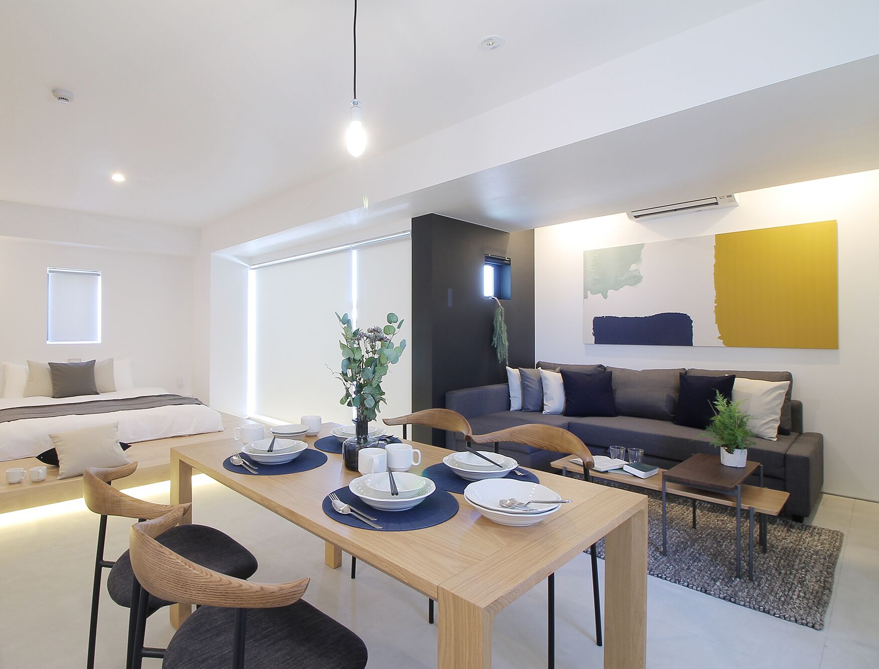 A modern living room with a dining area, a sofa, and a coffee table.