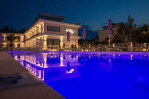 Una piscina al aire libre de temporada, sombrillas