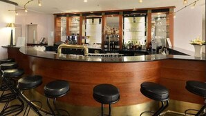 A bar area with stools, a counter, and shelves with bottles. - Kaiserin Augusta (Weimar)