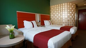 A hotel room with two beds, a round table with a vase of flowers, and a large window with a patterned curtain. - Benjoy Hotel Shanghai (Shanghai)