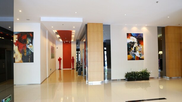 A modern lobby with a polished floor, a red accent wall, and abstract art on the walls. - Benjoy Hotel Shanghai (Shanghai)