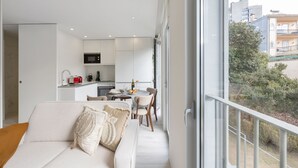 Un appartement moderne comprenant un espace de vie, une kitchenette et un coin repas.