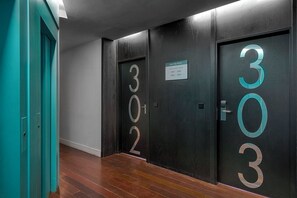A hallway with doors numbered 302 and 303, a sign indicating 'SEA TOP HOTEL,' and a teal door on the left. - Sea You Hotel Port Valencia (Valencia)