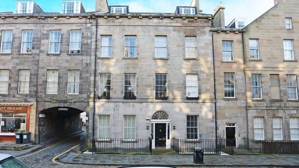 A historic stone building with multiple windows, a central entrance, and a small adjacent structure labeled 'Pavillion Thai Restaurant'. - JOIVY Vibrant City Centre 2-bed Apt. (Edinburgh)