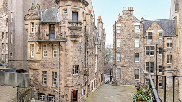 A historic stone building with multiple windows and a turret. - JOIVY Royal Mile Tower Apartment (Edinburgh)