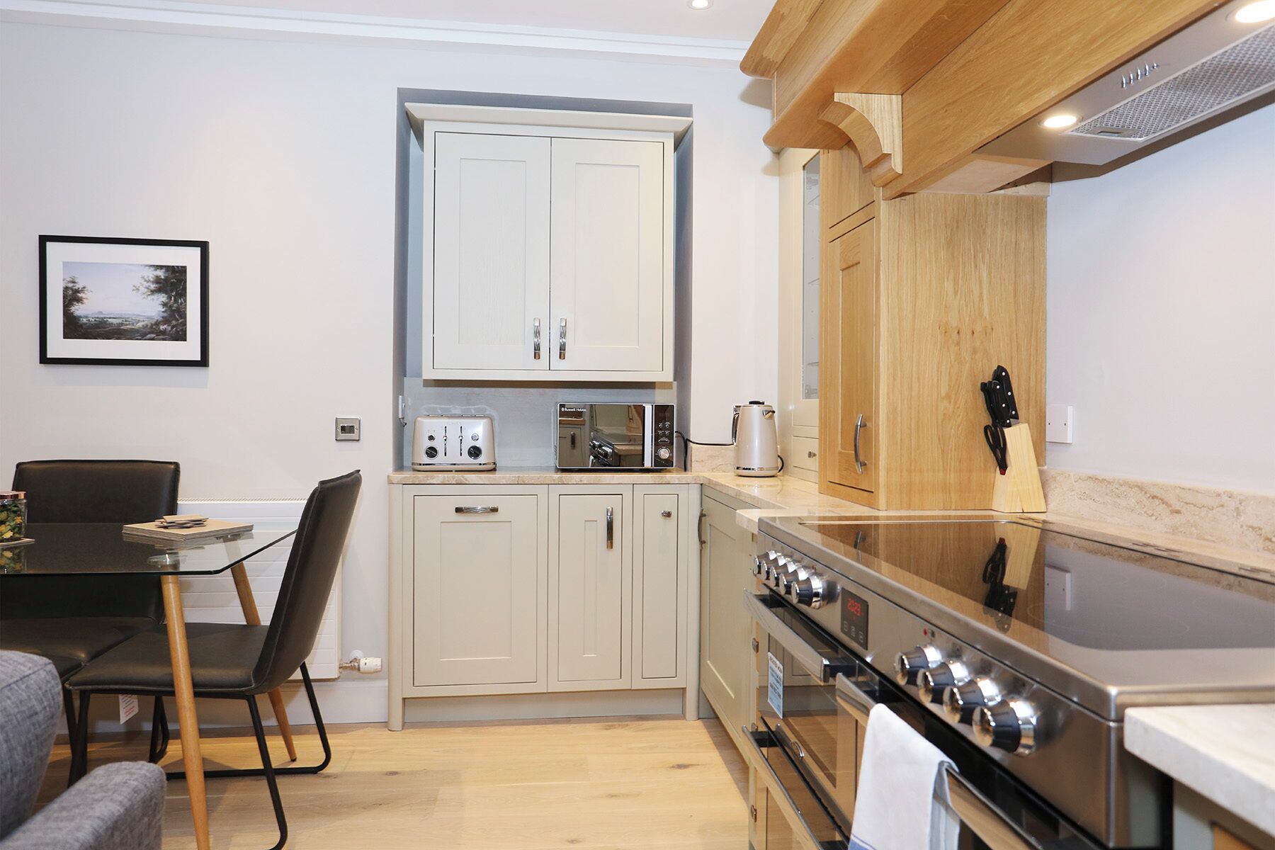 A compact kitchen with a dining area, featuring a stove, microwave, and cabinets.