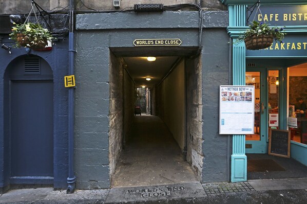 A narrow alleyway with a sign reading 'WORLD'S END CLOSE' leading to a building entrance.
