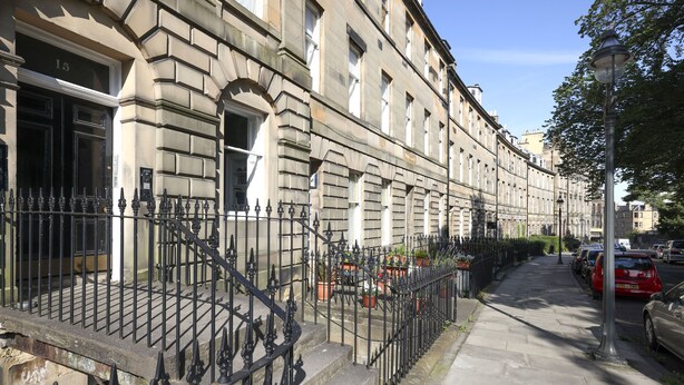 A row of historic buildings with a stone facade, black iron railings, and a sidewalk. - JOIVY Stunning Ground-floor 2bedrm New Town Apt (Edinburgh)