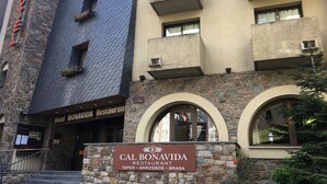 A hotel with a stone facade, a sign for Cal Bonavida Restaurant, and a staircase leading to the entrance. - Bonavida (Canillo)